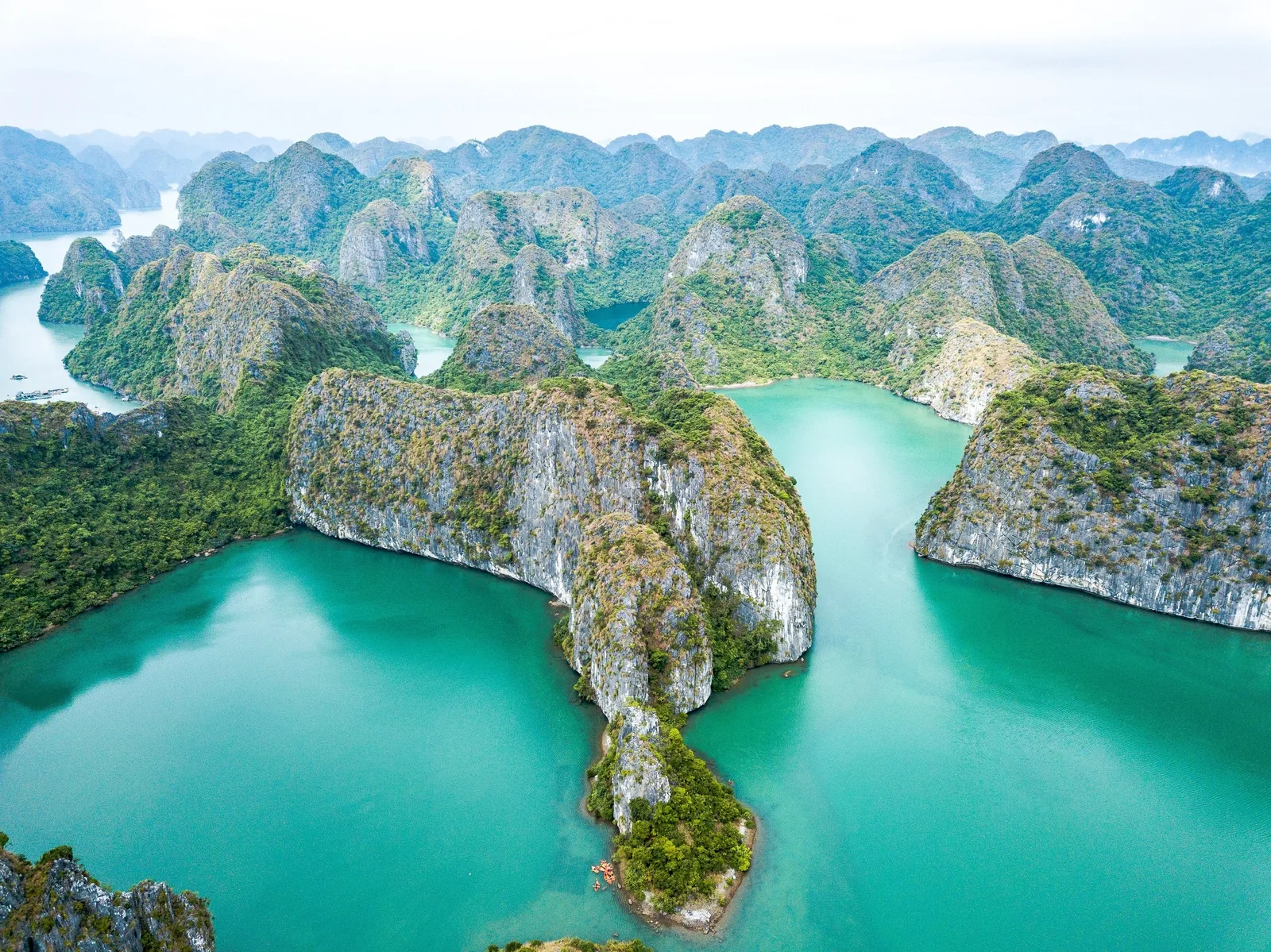 Aerial view of limestone karsts rising from turquoise waters in Ha Long Bay, Vietnam.
