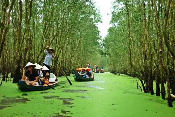 Small boats carrying passengers along a canal in the Mekong Delta near Ho Chi Minh City