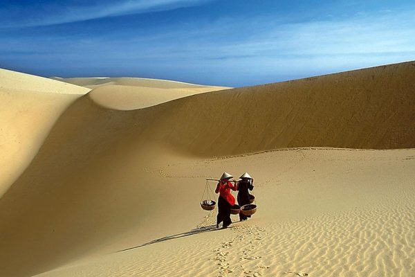 Rippled red sand dunes stretching toward the coast near Mui Ne